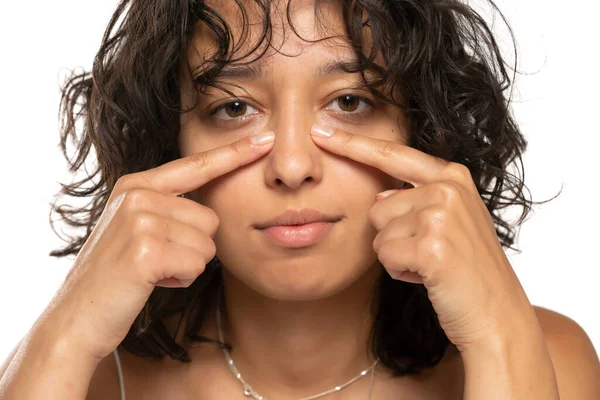 Genç Bir Kadın Beyaz Stüdyo Arka Planında Parmaklarıyla Burnuna Dokunuyor — Stok fotoğraf