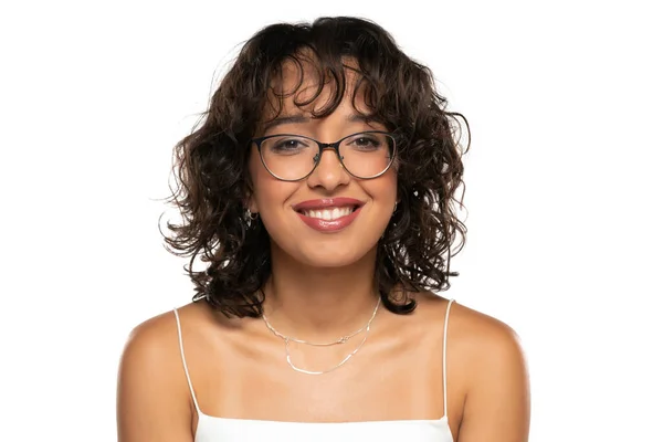Młoda Ciemnoskóra Uśmiechnięta Kobieta Makijażem Okularami Falowanymi Włosami Pozująca Białym — Zdjęcie stockowe