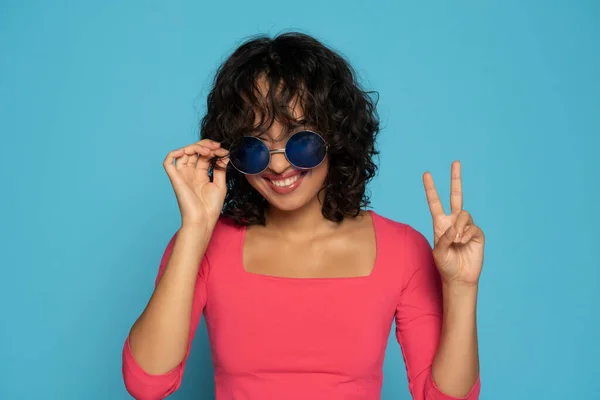 Młoda Egzotyczna Uśmiechnięta Brunetka Różowej Bluzce Pozująca Okularach Przeciwsłonecznych Niebieskim — Zdjęcie stockowe