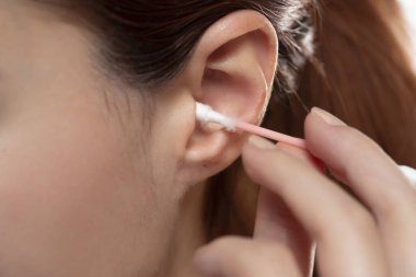 Young woman cleaning ear with cotton swab , closeup. clipart