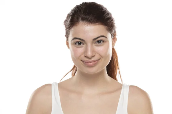 白いスタジオの背景に長い髪の化粧のない若い笑顔の赤毛の女性 — ストック写真