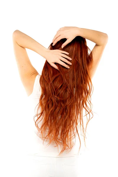 白いスタジオの背景に長いジンジャーの重い髪の赤毛の女性のバックビュー — ストック写真