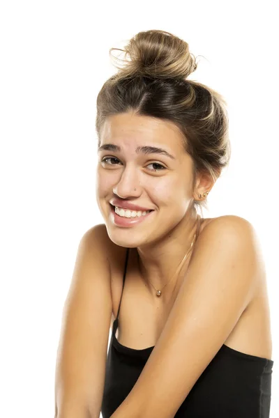 乱雑なルーズパンと白いスタジオの背景にメイクなしの若い笑顔の女性 サイドプロフィール — ストック写真
