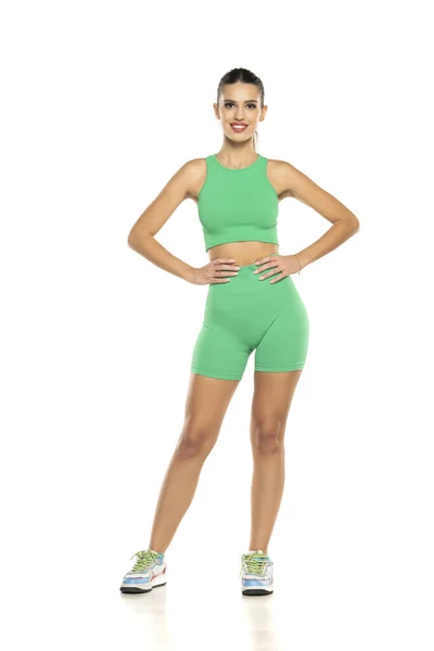 Giovane Donna Sportiva Sorridente Pantaloncini Verdi Top Posa Sfondo Bianco — Foto Stock