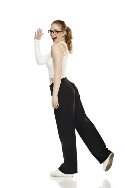 Vista Lateral Joven Mujer Rubia Feliz Pantalones Blusa Blanca Caminando — Foto de Stock