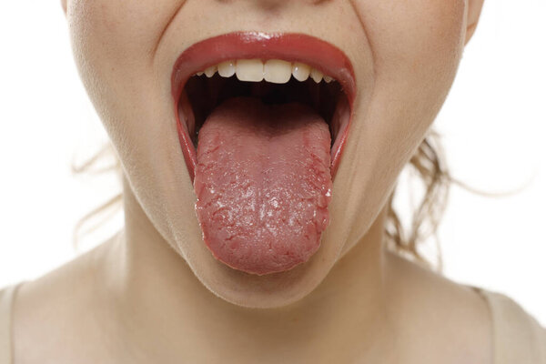 Close up of a woman mouth sticking tongue on a white studio background