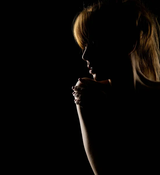 黒いスタジオの背景に肩に触れる若い女性のシルエット — ストック写真