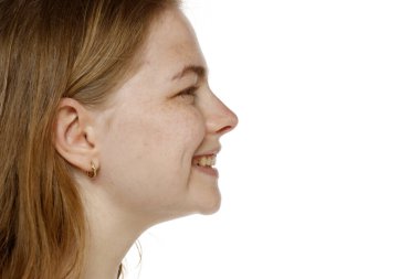 Beyaz bir stüdyo arka planında genç bir kadının yüzü, gülümsemesi, ağzı, burnu ve yanağı.