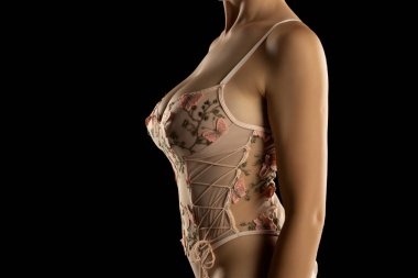 Siyah Stüdyo Arkaplan 'da, iç çamaşırlı seksi genç kadının gövdesi şeffaf tek parça bebek tulumu.