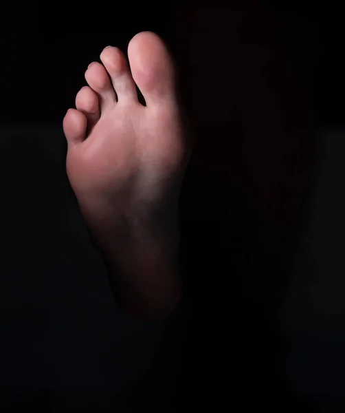 Sole and toes of the female foot on a black studio background