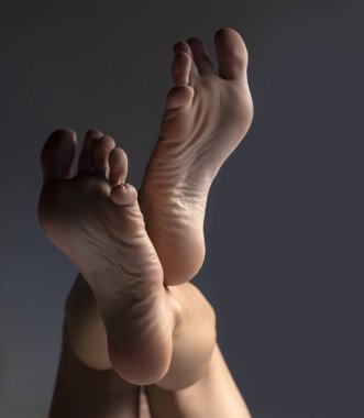 Gri stüdyo arka planında gölgeli ve ışıklandırmalı güzel bir kadın.