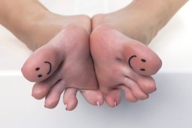 Üzerinde bir gülümseme olan kadın ayak parmaklarının yakın çekimi.