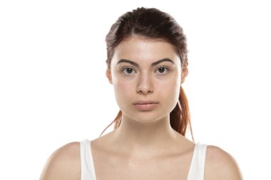 Makyajsız, beyaz stüdyo geçmişinde uzun saçlı, ciddi bir kızıl kadın.