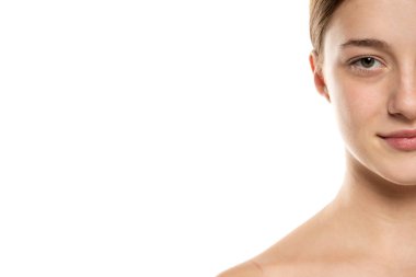 Güzellik abidesi gülümseyen, saçları tokalı, makyajsız genç bir kadının yarım portresi..