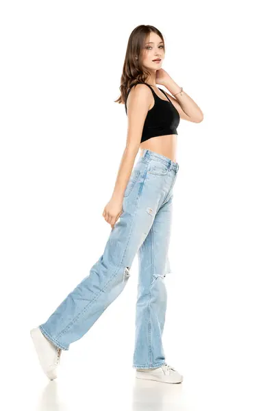 Młoda Modelka Podartych Dżinsach Czarnej Koszuli Bez Rękawów Chodząca Białym Zdjęcia Stockowe bez tantiem