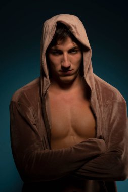 Koyu mavi kapüşonlu kaslı adam.