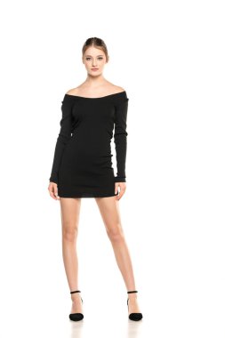 Yaz Şıklığı: Beyaz Stüdyo Arkaplanında Kısa Elbise ve Sandalet Giyen Genç Bir Kadının Uzun Portresi