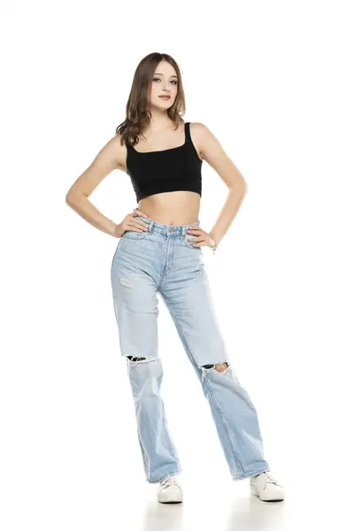 Mladá Modelka Roztržených Džínách Černé Košili Bez Rukávů Pózuje Bílém Stock Snímky