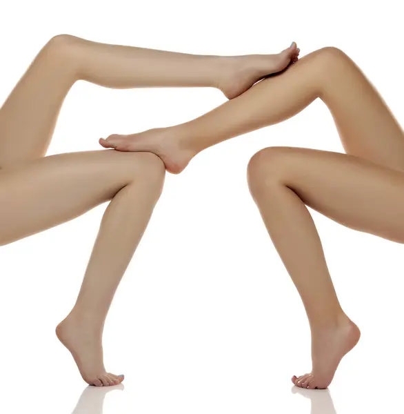2組のオッズ 白い隔離されたスタジオの背景に美しい整然とした女性の足のクローズアップ 足のスキンケアのエピレーションの概念 ストック画像
