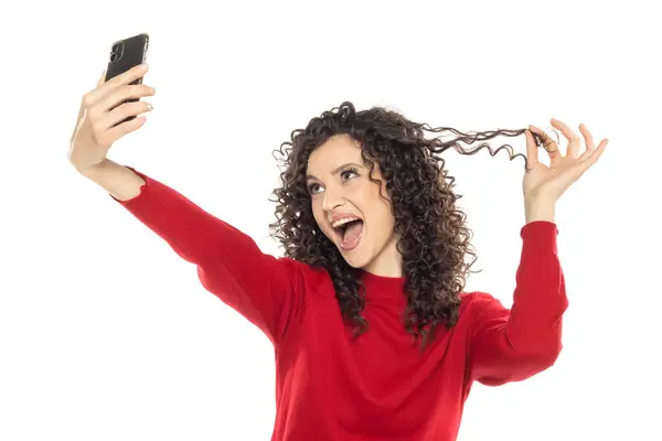 Glücklich Lockige Frau Macht Selfie Foto Auf Weißem Studiohintergrund lizenzfreie Stockfotos