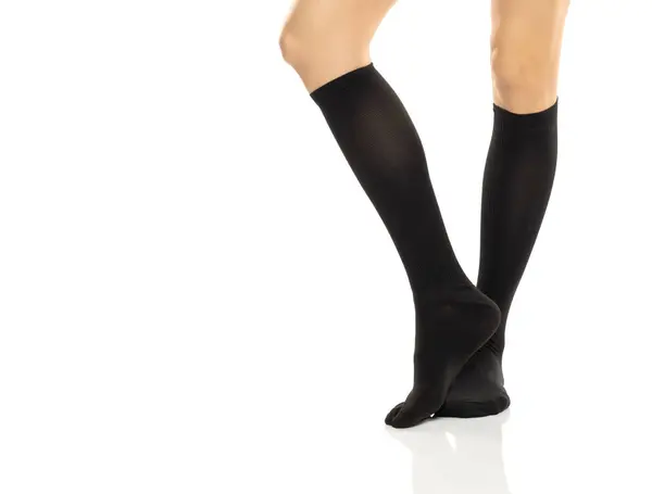 女性腿在压缩裤袜 医用长袜 紧身裤 小腿和袖子 用于静脉曲张和静脉治疗 临床针织 白色演播室背景的运动袜 免版税图库图片