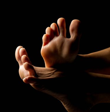 Yakın plan, ayak parmakları siyah stüdyo arka planında poz veren kadın ayakları.