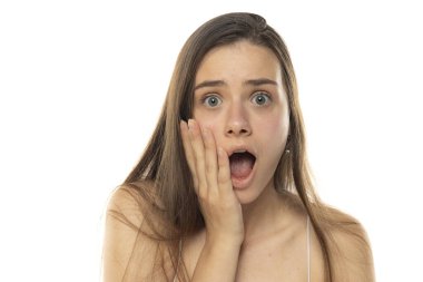 Beyaz bir stüdyoda makyajsız genç bir kızın portresi.