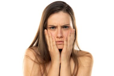 Beyaz bir stüdyoda makyajsız genç bir kızın portresi.