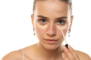 Beyaz bir stüdyo geçmişine kapatıcı süren güzel bir genç kadının portresi.