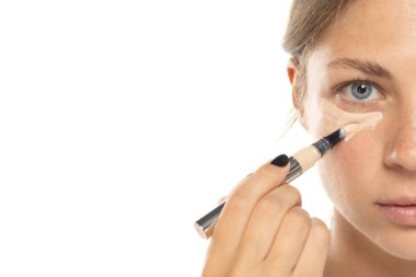 Beyaz bir stüdyo geçmişine kapatıcı süren güzel bir genç kadının portresi.