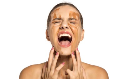 Güzel, çaresiz kadın yüzüne farklı tonlarda sıvı fondöten sürüyor.