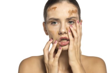 Yüzüne farklı tonlarda sıvı fondöten sürmüş güzel bir genç kadın.