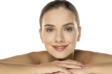 Güzel, genç, gülümseyen bir kadın beyaz üzerinde yatıyor. Deri, kozmetoloji.