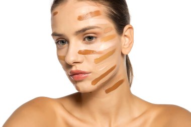 Yüzünde farklı bir sıvı fondöten tonuyla poz veren güzel genç kadın..