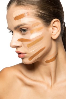 Yüzünde farklı bir sıvı fondöten tonuyla poz veren güzel genç kadın..