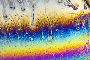 İnce sabun filmlerindeki dinamik etkileşim renklerinin soyut arkaplanı. Kabarcık gökkuşağı renkleri