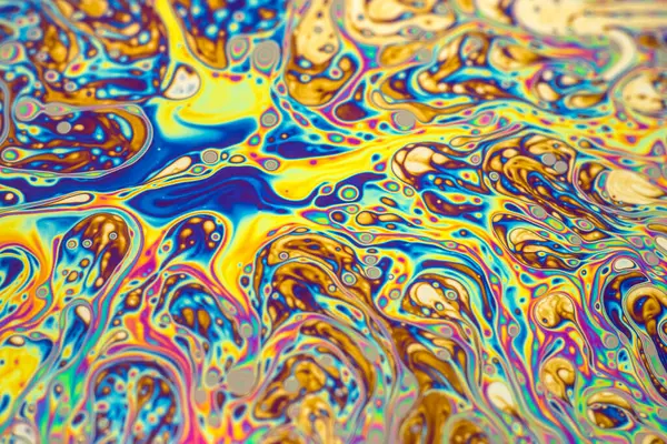 İnce sabun filmlerindeki dinamik etkileşim renklerinin soyut arkaplanı. Kabarcık gökkuşağı renkleri