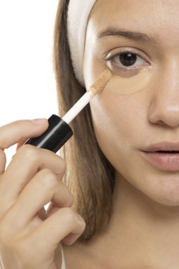 Güzellik. Gözlerinin altına beyaz bir arkaplan süren genç bir kadın. Yarım yüz.