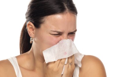 Beyaz stüdyo arka planına ıslak mendille burnunu silen bir kadının portresi.