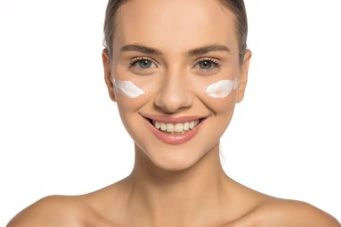 Yüzünde kozmetik ürünüyle poz veren güzel, genç bir kadın.