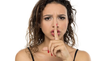 Makyajlı genç bir kadın mutsuz ve hayal kırıklığına uğramış görünüyor. Kırışık kaş ve yoğun ifade. Beyaz arkaplanda stüdyo resmi.