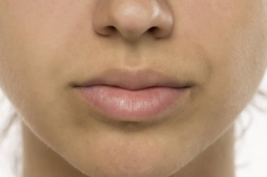 Doğal, makyajsız dudaklar ve cilt. Detaylı görünüm dokuyu, ince çilleri ve yumuşak dudak rengini gösteriyor. Cilt bakımı ve güzellik kavramı.