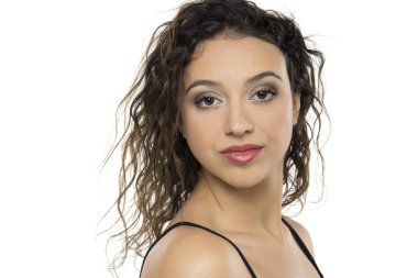 Makyajlı, kıvırcık saçlı ve kırmızı rujlu genç bir kadın. Beyaz arka planda profesyonel stüdyo portresi, kendine güvenen ve cilalı görünümü gösteriyor.