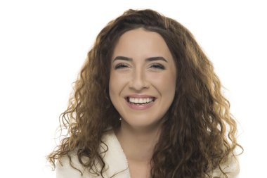 Beyaz bornozlu, kıvırcık kahverengi saçlı kadın beyaz arka planda içten bir gülümseme, gerçek mutluluk, dostça bir ifade, doğal bir portre..