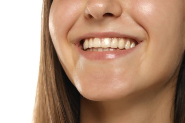 Genç bir kadının gülümsemesi doğal dişlerini, dudaklarını ve çene bölgesini gösteriyor. Diş sağlığı kavramı..