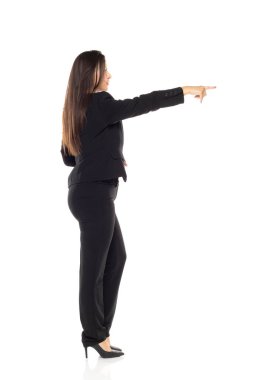 Siyahlı profesyonel iş kadını, liderlik ve yönünü gösteren beyaz arkaplan karşısında otorite ve profil görüşüyle ileri bakıyor.