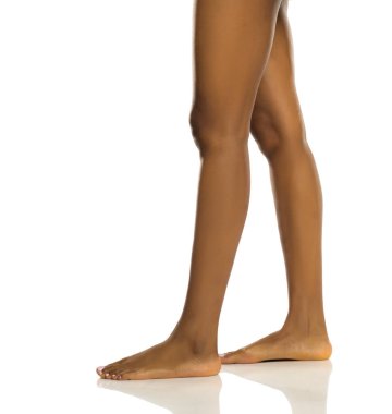 Ayakta duran siyah bir kadının zarif çıplak bacakları, beyaz arka planda yan görüş stüdyosu.