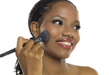 Gülümseyen siyah kadın makyaj yapıyor fırça, güzellik konsepti, beyaz arka planda stüdyo çekimi