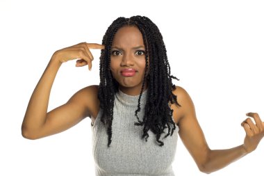 Kafasını karıştıran, hayal kırıklığına uğramış bir ifadeyle, mantığı veya sağduyuyu sorgulayan siyahi bir kadının beyaz arkaplan görüntüsü..