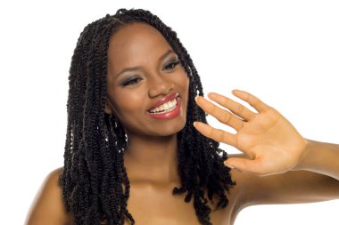 Güzel siyah kadın gülümsüyor ve eline bakıyor, temiz ve cilalı tırnaklarını gösteriyor, beyaz arka planda stüdyo çekimi.